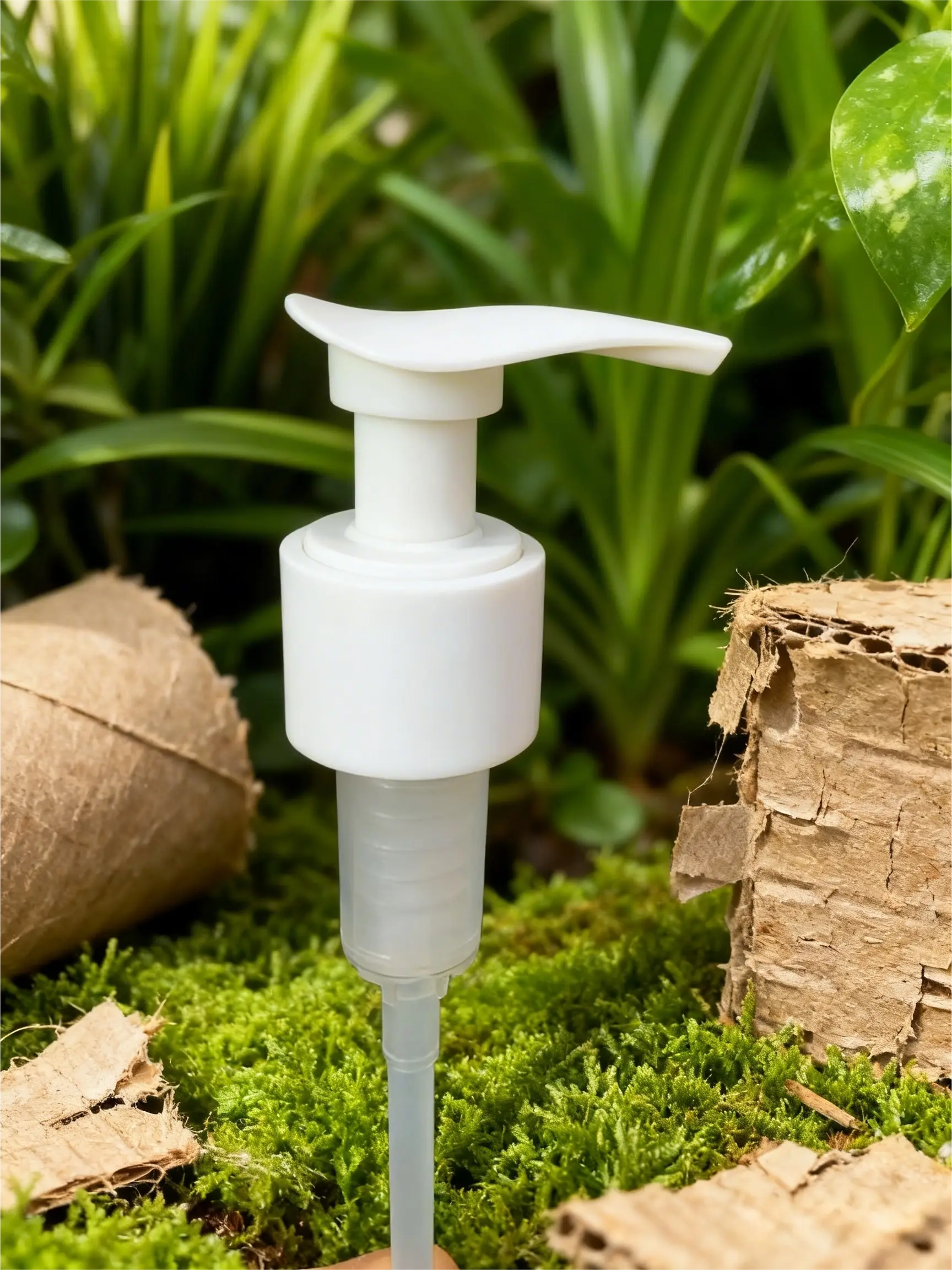 Sustainable all-white plastic monomaterial pump dispenser for skincare on lush green moss with cardboard props.